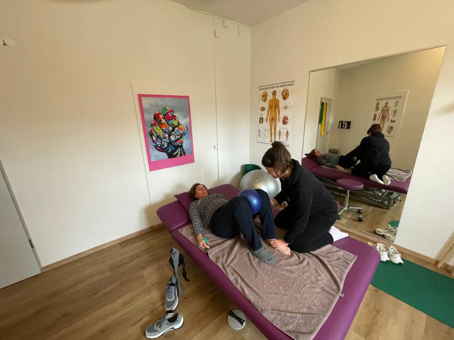 Physiotherapeutin behandelt eine liegende Patientin auf der Therapieliege