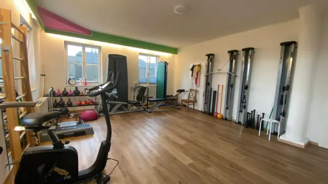 Trainingsraum mit Hanteln, Beinpresse und Seilzügen
